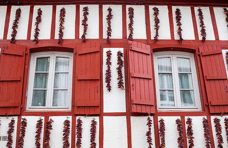 Photo de façades du pays-basque avec des piments d'Espelette séchés