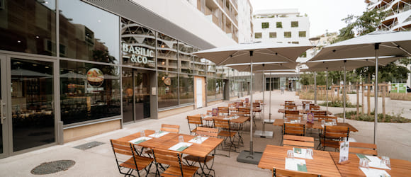 Tables en bois dressées, sur la terrasse de la pizzeria Basilic & Co Montpellier (Saint-Roch)