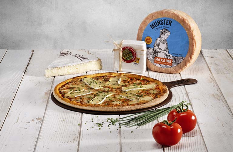 Carte printemps-été : Pizza 3 fromages de Lorraine entourée du Munster AOP, du Carré du Père Antoine et du Brie de Meaux AOP
