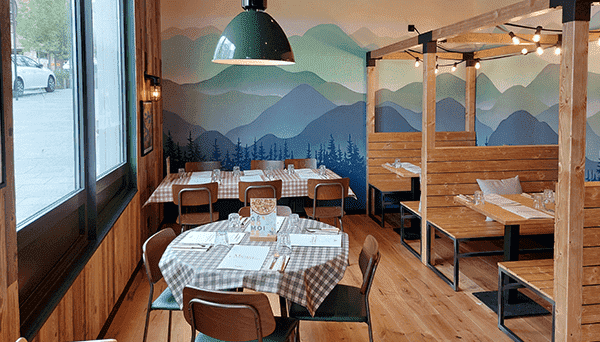 restaurant de Chatenay-Malabry. On aperçoit une table ronde avec une nappe à carreaux, une table rectangulaire et deux cahutes en bois où l'on peut se restaurer.